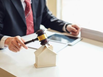 Lawyer holding a hammer at the property auction house at the office.